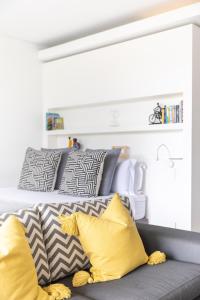 a couch with yellow and gray pillows in a room at 204 Juliette in Cape Town