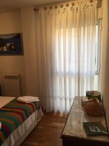 um quarto com uma cama e uma janela com cortinas em EL RINCÓN DE TORRENUEVA em Zaragoza