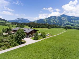 una vista aérea de una casa en un campo con montañas en Weberhof Hopfgarten, en Hopfgarten im Brixental