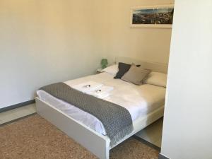 Dormitorio pequeño con cama con sábanas y almohadas blancas en A due passi da Giulietta-Casa Montecchi, en Verona