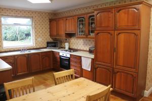 a kitchen with wooden cabinets and a wooden table at Brookside Lodge in Baldock