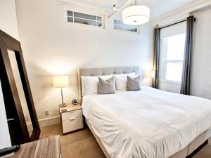 a bedroom with a white bed and a window at The Haus On Mirror Lake in Lake Placid