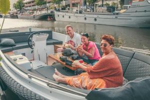 un grupo de personas sentadas en un bote en el agua en H2OTEL Rotterdam, en Róterdam