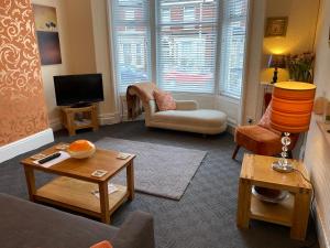 a living room with a couch and a tv at Blackpool Holiday Lets -GF Regent Road in Blackpool