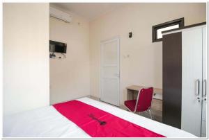 A bed or beds in a room at RedDoorz Syariah @ Jatinegara