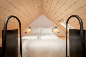 Cama blanca en habitación con techo de madera en The Cupboard , Cosy Weavers Cottage , Wood Burner, en Elie