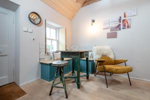 Habitación con mesa, sillas y reloj en The Cupboard , Cosy Weavers Cottage , Wood Burner, en Elie