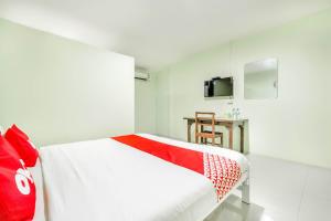 a white room with a bed and a television at OYO 722 I Oun Inn in Nakhon Nayok