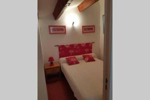 a bedroom with a bed with two red pillows on it at Pavillon Grazel GRUISSAN in Gruissan