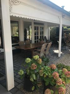 een patio met een houten tafel en bloemen bij Bed and Breakfast Azzurro in Bokhoven