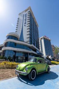 un coche verde estacionado frente a un edificio en Novotel Konya, en Konya