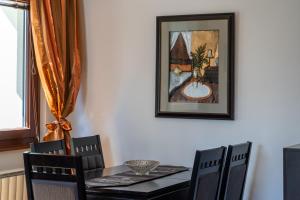 a dining room table with chairs and a picture on the wall at Zlatiborski Konaci in Zlatibor