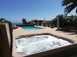 - un bain à remous installé sur une terrasse à côté de la piscine dans l'établissement Villa Sin Pena, à Tías
