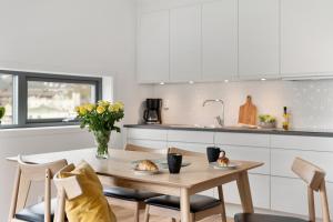 uma cozinha com uma mesa de madeira e cadeiras numa cozinha em BJØRVIKA APARTMENTS, Damsgård Area, Bergen city center em Bergen