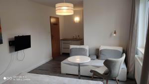 a living room with a couch and a table at Pokoje 100 m od morza in Dziwnów