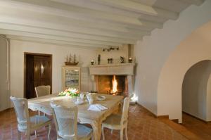 a dining room with a table and a fireplace at Le Mas du Chanoine in Saint Paul de Vence