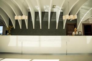 a woman sitting at a counter in a lobby at GARDELLI RESORT in Laganas
