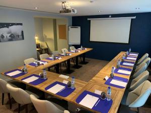 a meeting room with long wooden tables and chairs at Best Western Empire Elysees in Paris
