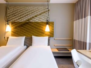 ein Hotelzimmer mit 2 Betten und einem Schreibtisch in der Unterkunft ibis Regensburg Zentrum in Regensburg