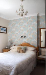 um quarto com uma cama com papel de parede floral em Whitecroft B&B em Edinburgo