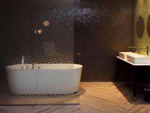 a bathroom with a tub and a sink at Pullman Sharjah in Sharjah