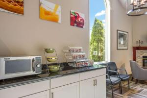 Quality Inn & Suites في غورهام: مطبخ مع كونتر مع ميكروويف وكراسي