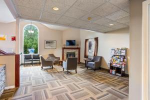 a waiting room with chairs and a fireplace at Rodeway Inn in Gorham