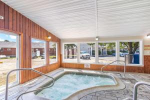 a hot tub in a room with windows at Rodeway Inn in Gorham