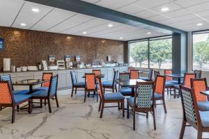 a restaurant with tables and chairs and a counter at Clarion Pointe Raleigh Midtown in Raleigh