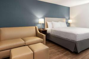 a hotel room with a bed and a couch at WoodSpring Suites Quantico in Stafford