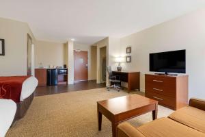 a hotel room with a bed a desk and a television at Comfort Inn & Suites Macon West in Macon