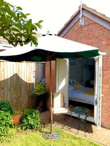 a bed and an umbrella on a patio at The Annexe in Waltham