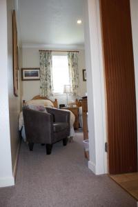 a bedroom with a chair and a bed and a window at Whitecroft B&B in Edinburgh