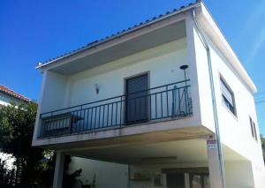 un edificio blanco con un balcón en el lateral. en Casa da Oliveira, en Milhão