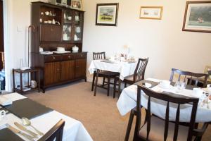 a dining room with tables and chairs and a kitchen at Whitecroft B&B in Edinburgh