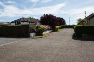 a driveway of a house with bushes and trees at Whitecroft B&B in Edinburgh
