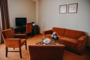 ein Wohnzimmer mit einem Sofa, Stühlen und einem Tisch in der Unterkunft Hotel BELASSI in Bojnice