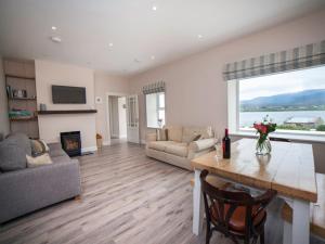 a living room with a table and a fireplace at Barr an Uisce in Achill Sound
