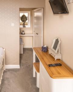 a room with a counter with a television and a mirror at Rose and Crown Bath in Hinton Charterhouse