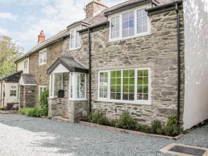 a stone house with white windows and a driveway at 3 Rock Terrace in Llangollen