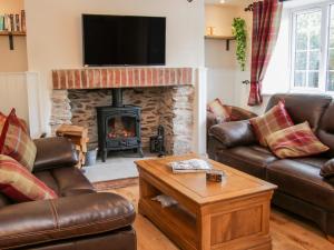 a living room with leather couches and a fireplace at 3 Rock Terrace in Llangollen