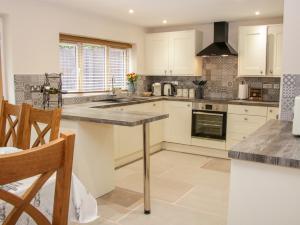 a kitchen with white cabinets and a counter top at 3 Rock Terrace in Llangollen