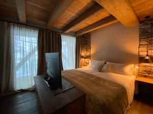 a bedroom with a bed with a tv in it at Les Neiges D'Antan in Breuil-Cervinia +76 photos