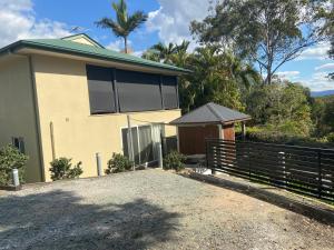 a house with a fence in front of it at Eatons Hill Hidden Valley Retreat in Eatons Hill