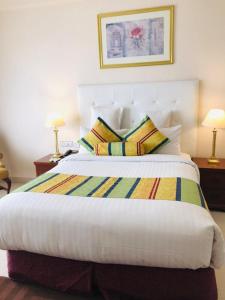 a bedroom with a large bed with two pillows at Beach Luxury Hotel in Karachi