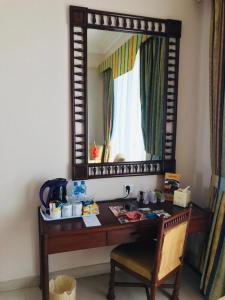 a desk with a mirror and a chair at Beach Luxury Hotel in Karachi