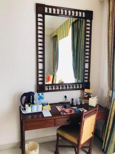 a desk with a mirror and a chair at Beach Luxury Hotel in Karachi