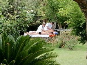 a group of people sitting on beds in a garden at Villino Eleonora in Parghelia