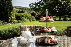 a table with a tray of bread and pastries and cups at Falcon Manor Hotel in Settle