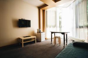 um quarto com uma cama, uma mesa e uma televisão em Crystal Hotel em Estosadok